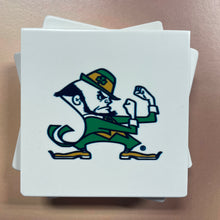 Load image into Gallery viewer, Stack of white stone coasters with a green and white logo on a beige surface