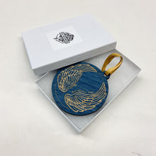 Load image into Gallery viewer, This Johnson Family Hall Christmas Ornament is made from blue stained birch, laser-engraved, and is 3.25" in diameter.