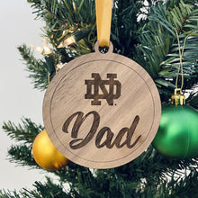 Load image into Gallery viewer, The ND Mom ornament is made from birch while the ND Dad ornament is made from walnut. Both ornaments in this Notre Dame Mom & Dad Christmas Ornament Set are laser-engraved and 3.25" in diameter.
