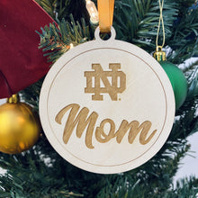 Load image into Gallery viewer, The ND Mom ornament is made from birch while the ND Dad ornament is made from walnut. Both ornaments in this Notre Dame Mom & Dad Christmas Ornament Set are laser-engraved and 3.25" in diameter.