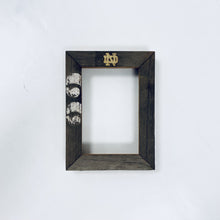 Load image into Gallery viewer, These frames are available in landscape or portrait, are engraved with a "gold-leaf" Notre Dame Monogram above and your message or personalization can be added below. Glass and backing are included.
