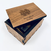 Load image into Gallery viewer, The engraved Notre Dame Whiskey Stones are presented in a laser-cut, handmade box, crafted from walnut wood and engraved with the ND Monogram. The stones are .75" square and the box measures 4" x 3" x 2.25".