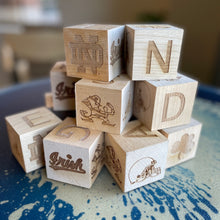 Load image into Gallery viewer, Each 2" x 2" block in this 16-block set is engraved on all 6 sides. Your child can spell NOTRE DAME and GO IRISH as well as enjoy the ND Monogram, Shamrock, Irish, Leprechaun, and an Irish football helmet!