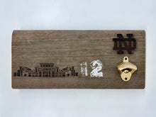 Load image into Gallery viewer, Our Notre Dame Stadium Bench Wood Bottle Opener is crafted from a full 16-inch stretch of stadium bench.