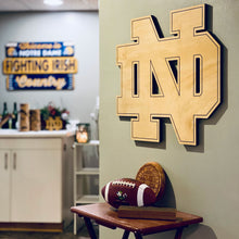 Load image into Gallery viewer, This beautiful Notre Dame Monogram is crafted from golden, UV-prefinished 1/2" plywood and features a lasered pin-stripe outline. It measures 30" x 33".