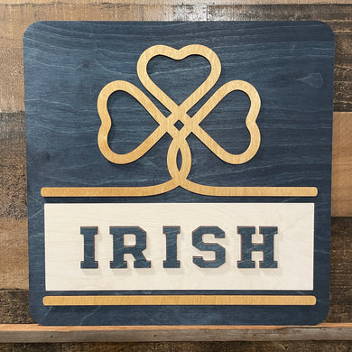 Wooden sign with a four-leaf clover design and 'IRISH' text on a wooden background