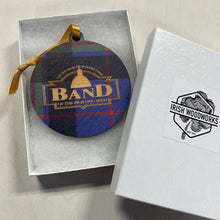 Load image into Gallery viewer, Round plaid ornament with &#39;BAND&#39; text in a box, featuring the Irish Woodworks logo.
