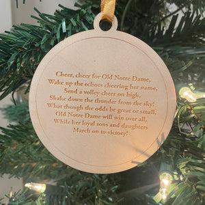 Round wooden ornament with text on a Christmas tree